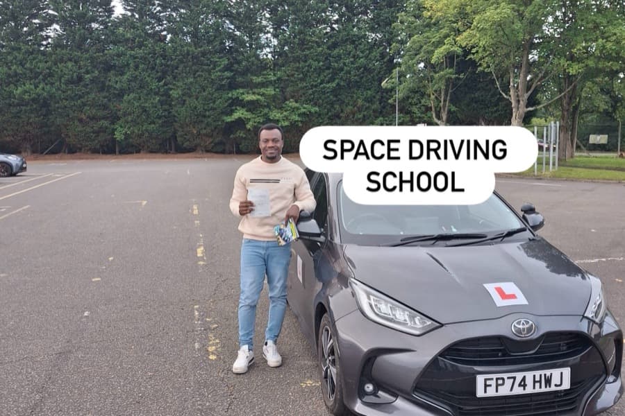 Passed learner standing beside a Space Driving School learner car