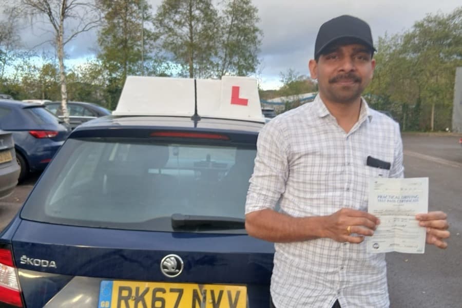 Passed learner holding their practical driving test pass certificate