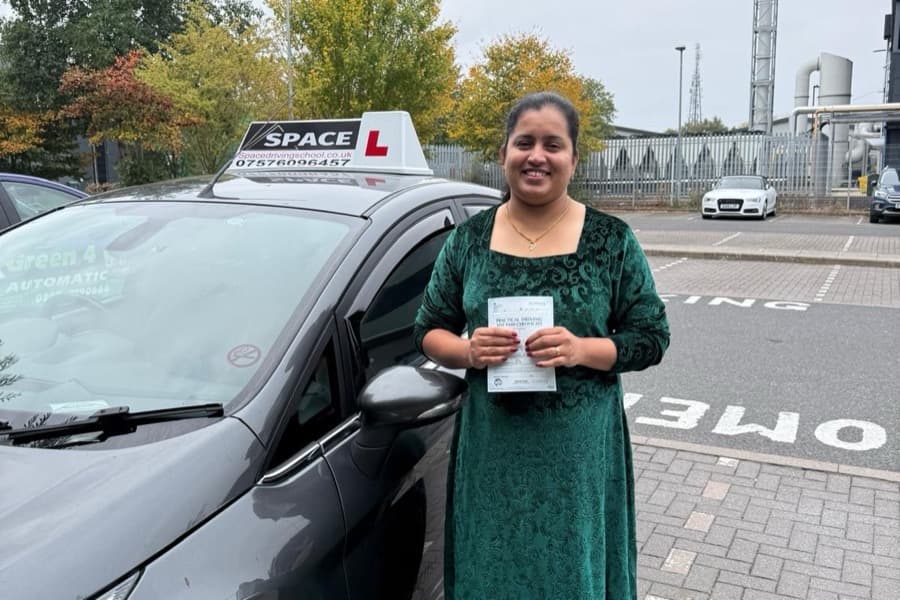 Passed learner celebrating beside a Space Driving School car